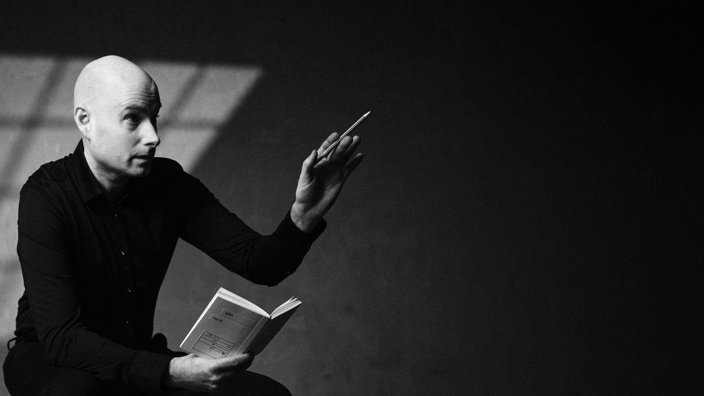 Michael Wax with a pencil and book in his hands